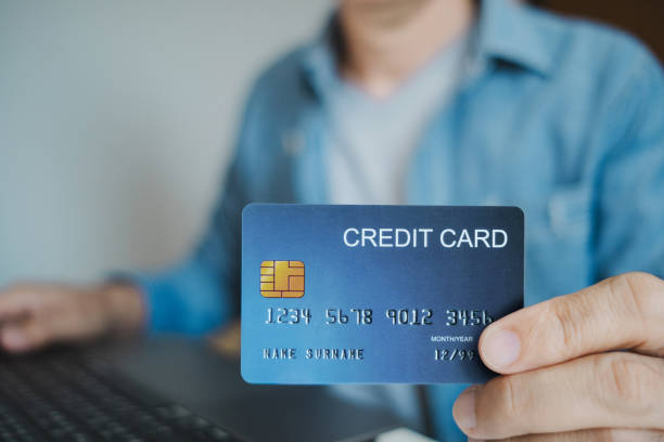 istock Close up, Man holding credit card while using laptop, shopping online, buying on internet. e-commerce e-banking service. 2196012373