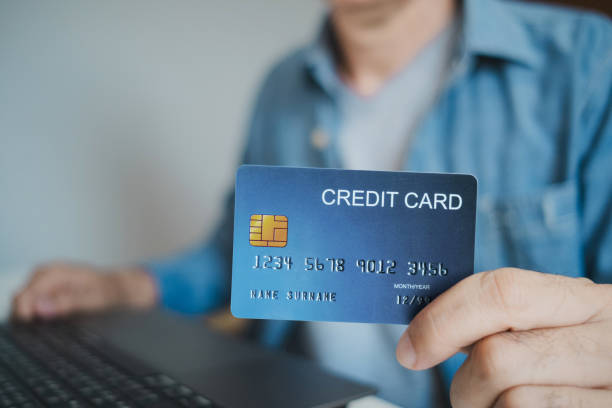 istock Close up, Man holding credit card while using laptop, shopping online, buying on internet. e-commerce e-banking service. 2196012382