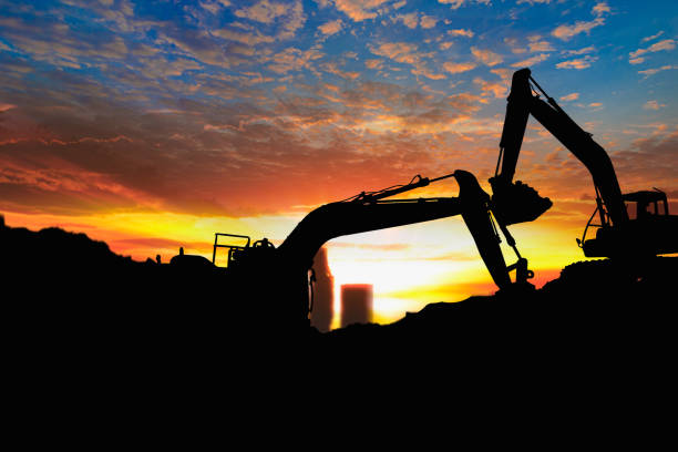 istock Crawler excavators silhouette are digging the soil in the construction site 2196017814