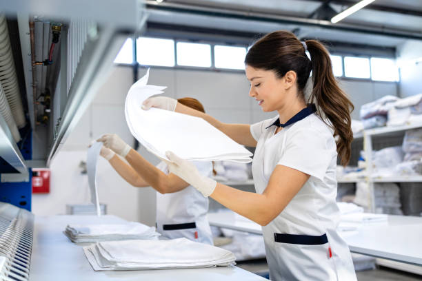 istock Dry cleaning service. Folding clean laundry and preparing for packing. 2196019181