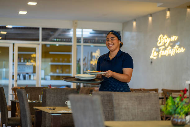 istock Waitress prepares the table and arranges everything to wait for the arrival of the diners 2196021663