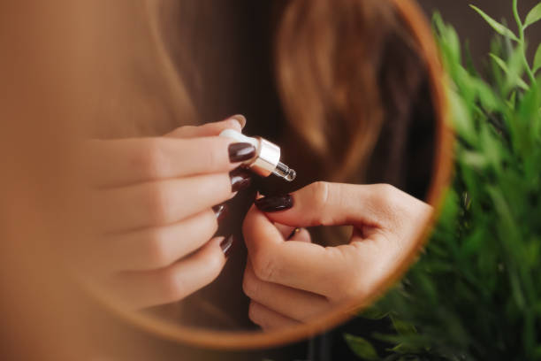 istock Nail care serum with dropper for hydration. Cuticle oil application in a beauty routine. Skincare hands and nails manicure. 2196022641
