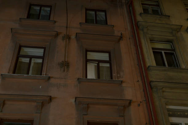 A tall building that features numerous windows is beautifully illuminated during the nighttime hours, creating a stunning visual effect