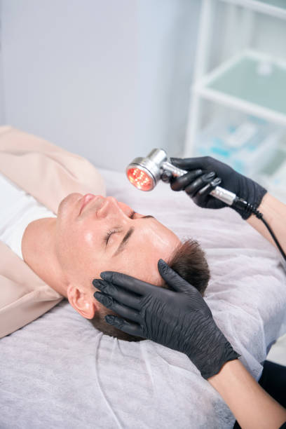 istock Relaxed man lying on treatment bed during red light therapy 2196029970