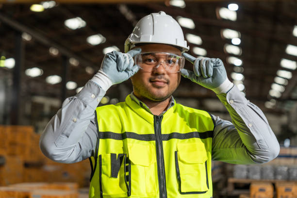 Close up technician engineer wearing and adjust protective safety glasses. Safety equipment for industry factory. Safety at work concept.