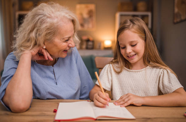 istock A grandmother helps her granddaughter while she studies and does her homework 2196031355