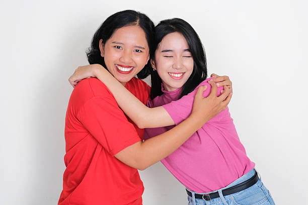 Two young girl hugging each other with happy face