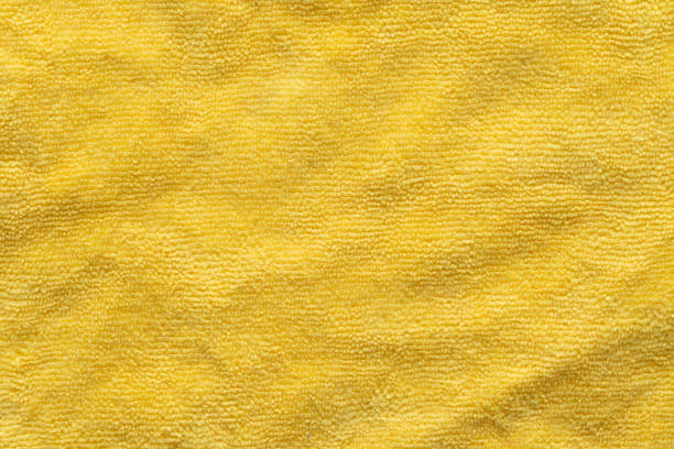 Clothing fabric yellow microfiber texture background, close up of cloth textile surface abstract.
