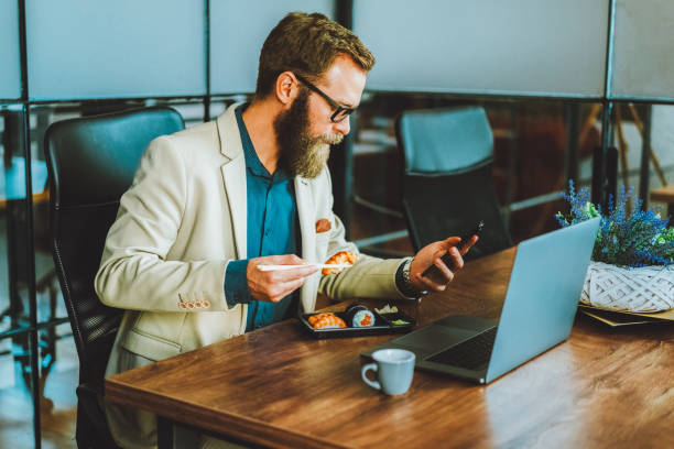 istock Businessman eating sushi in the office 2196032939