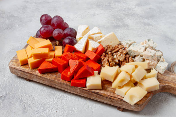 istock Assorted cheese on a wooden board, with grapes and walnuts, appetizer, no people. 2196033056