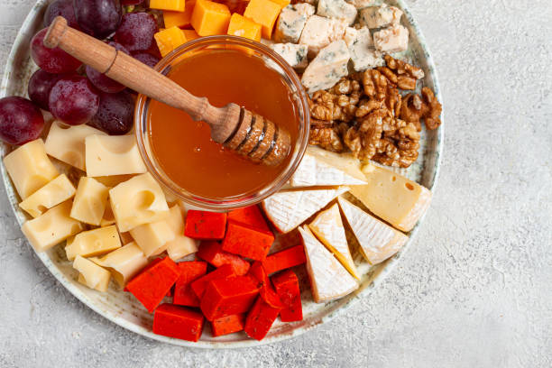 istock Appetizer, assorted cheese, with nuts and honey, on a round plate, top view, no people, 2196033089