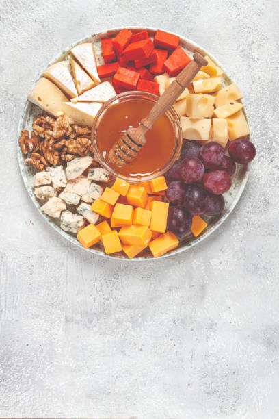istock Appetizer, assorted cheese, with nuts and honey, on a round plate, top view, no people, 2196033968