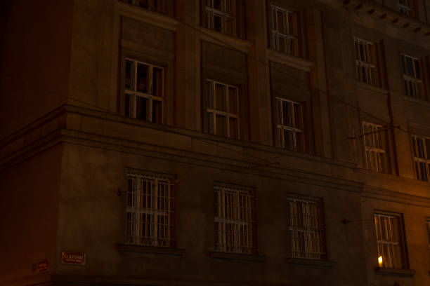 A historic buildings exterior illuminated at night highlights its windows and softly lit interior