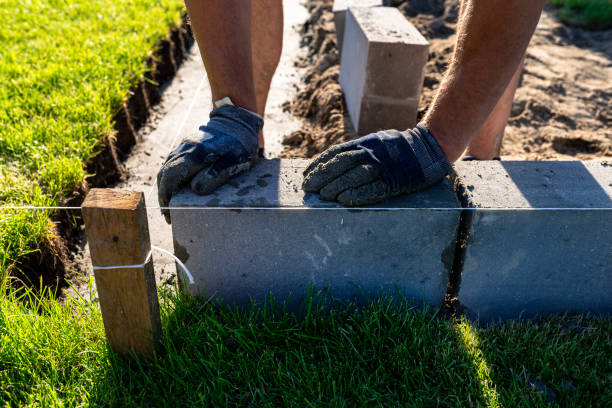 istock A man lays concrete blocks on a poured foundation, gluing them with mortar. 2196035772