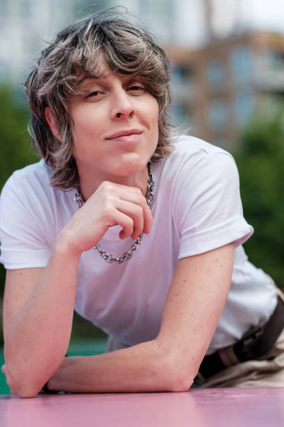 istock Young stylish person leaning on pink surface in urban setting 2196038903