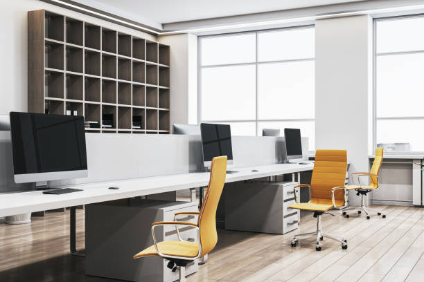 istock Modern office workspace with desks, computers, and yellow chairs in a bright interior. 3D Rendering 2196039289