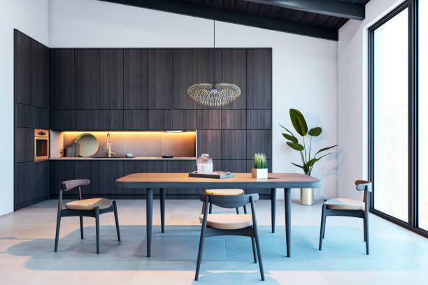 istock Modern kitchen interior with dark wood cabinets, dining table, and chairs in a loft-style apartment with large windows and city view. 3D Rendering 2196039425