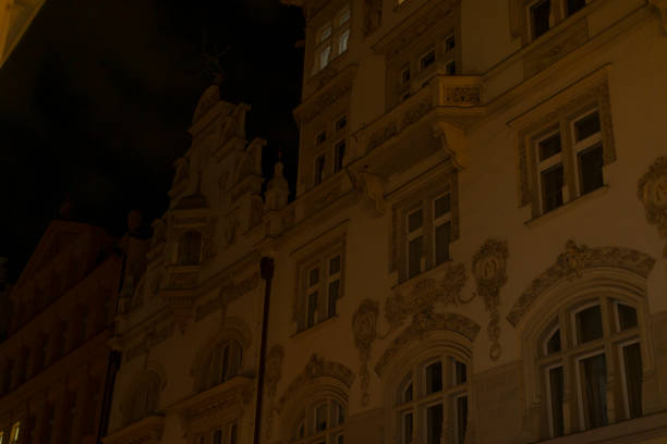 Golden illuminated façade of historic architecture with intricate details and stone carvings.