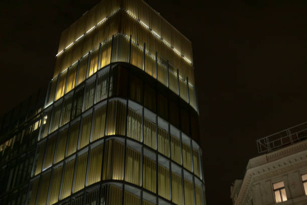 An illuminated contemporary glass structure beautifully stands out at night, showcasing the brilliance of urban architecture in a modern cityscape, captivating passersby with its design