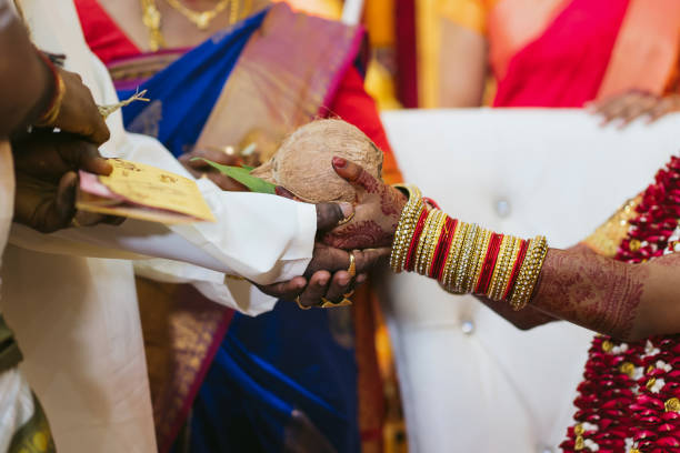 istock Groom and bride's palms stacked together, with a coconut placed on top during the wedding ceremony. South Indian Hindu wedding ceremony. 2196047493