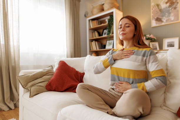 istock Serene woman practicing mindfulness meditation on sofa at home 2196048968