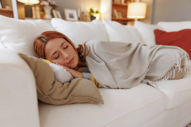 istock Serene young woman sleeping peacefully on a comfortable sofa, enjoying a restful nap at home 2196049108