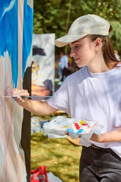 istock Young female artist painting outdoors in bright sunlight 2196049497