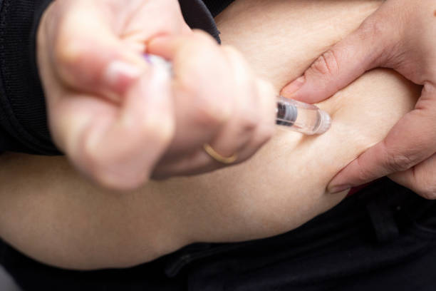 A person pressing an injection pen into the abdomen, self-administering semaglutide, a medication used for weight loss and diabetes control. This image highlights the ease of use of GLP-1 receptor agonists in personal healthcare.