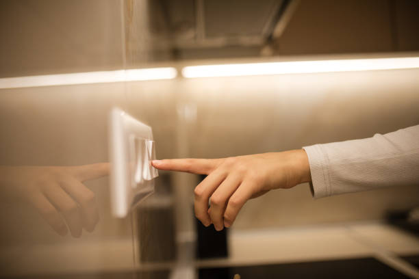 Unrecognisable woman turning on light switch at home, image taken in Europe, Serbia, city of Niš