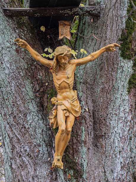 istock Jesus on the cross, embedded in a tree trunk 2196059557