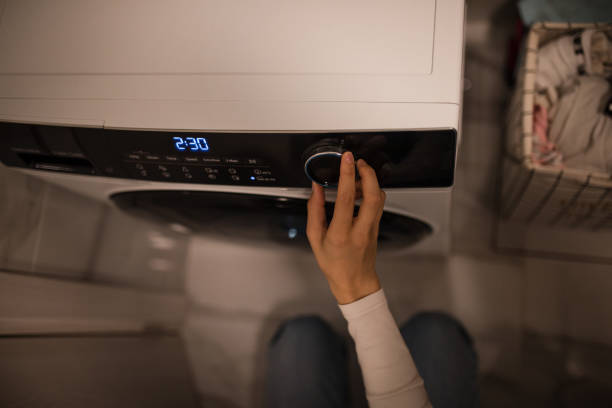 Young woman using washing machine at home, image taken in Europe, Serbia, city of Niš