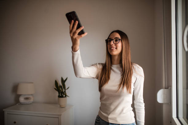 istock Young beautiful woman controlling security system with mobile app 2196059740