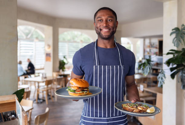 istock Waiter serving food at a restaurant and smiling 2196060872