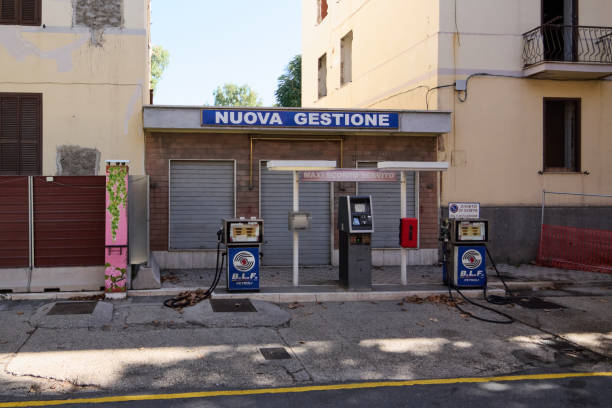 Civitavecchia. Italy - January 26, 2025: Closed gas station in an urban setting in Civitavecchia, Italy. Features vintage fuel pumps and signage NUOVA GESTIONE and MAXI SCONTO SERVITO.