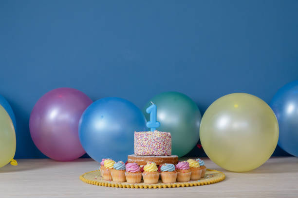 istock First birthday cake with party balloons 2196063677