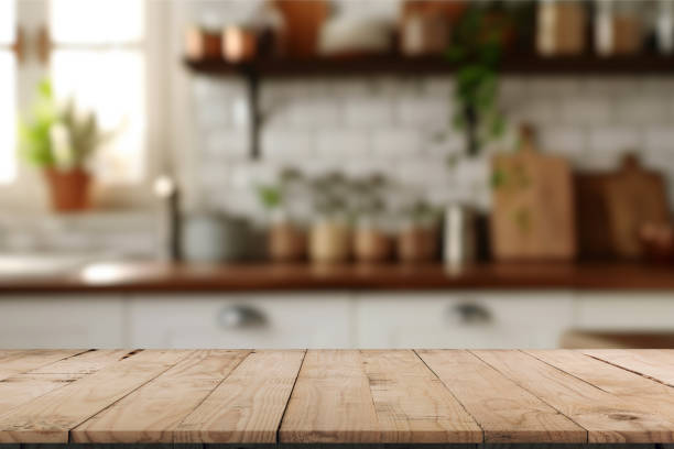istock A kitchen interior, focusing on a wooden table or countertop in the foreground. The table has a natural wood finish with visible grain patterns. The ambiance is warm and inviting. 2196065260