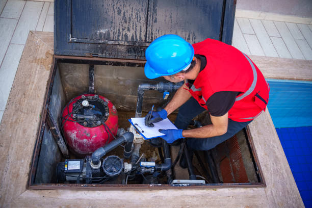 male maintenance worker checking and fixing pipes and water pumping machines