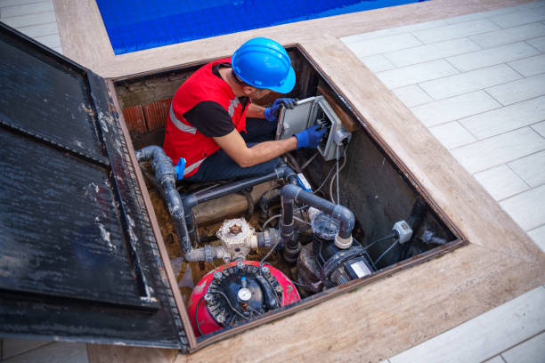 male maintenance worker checking and fixing pipes and water pumping machines