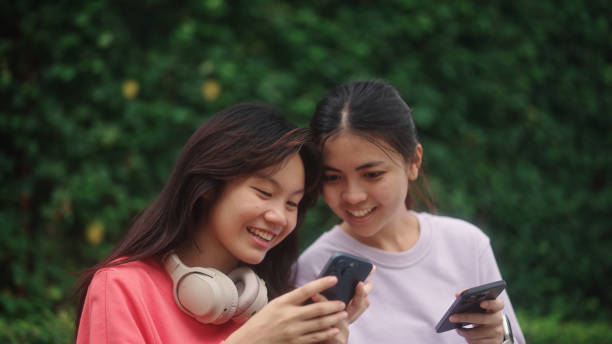 istock Teenagers using smartphone together outdoors. 2196071890