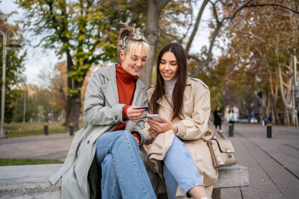 istock Female friends using smartphone for online payment 2196071976
