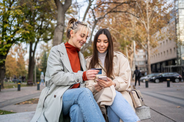 istock Female friends using smartphone for online payment 2196072077