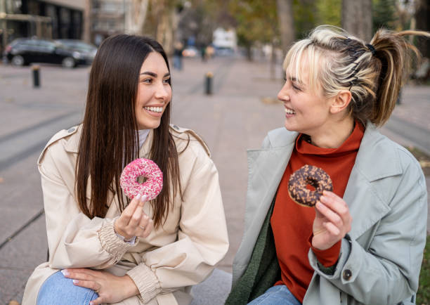 istock Female friends enjoying eating donuts 2196072235