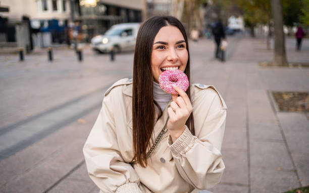 istock Woman enjoying eating a donut 2196072382
