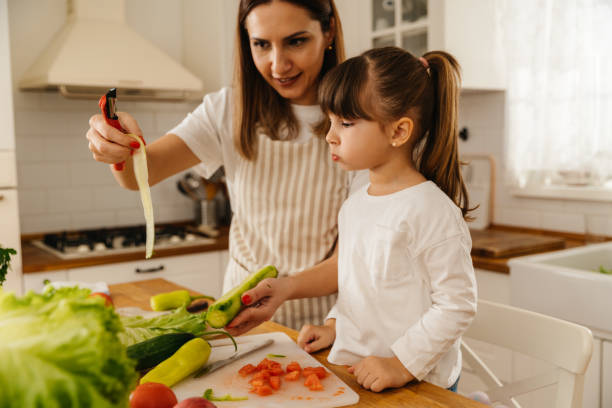 istock Mother and daughter making salad together 2196074341