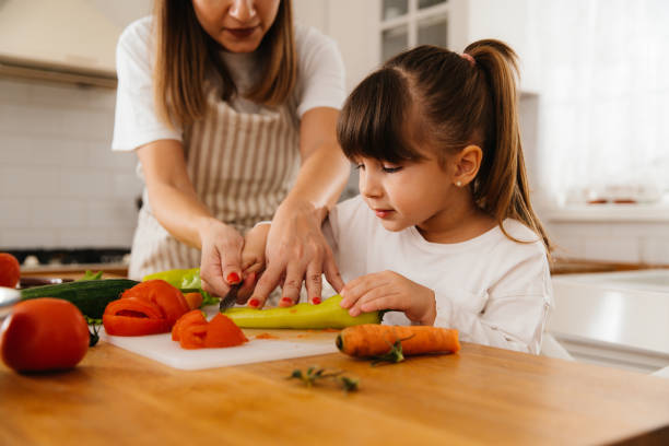 istock Mother and daughter making salad together 2196074435