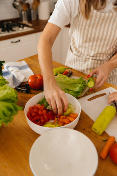 istock Mother and daughter making salad together 2196074618