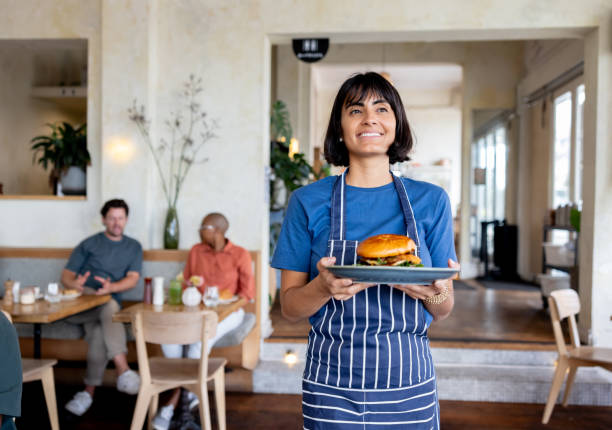 istock Happy waitress serving a burger at a restaurant 2196076638