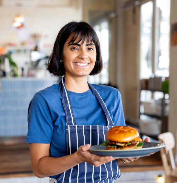 istock Happy waitress serving a burger at a restaurant 2196076640
