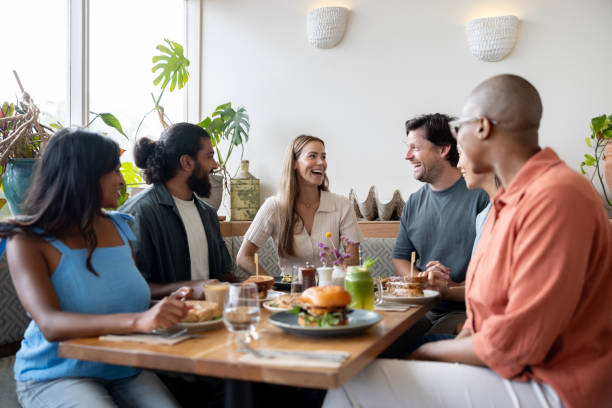 istock Happy group of friends talking at a restaurant 2196076653