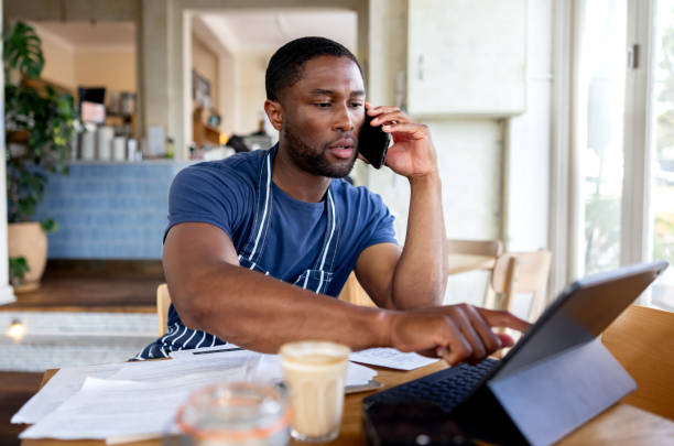 istock Coffee shop manager talking on the phone while doing the accountancy 2196076677